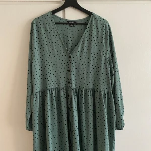 Grön prickig skaterklänning Monki- Nyskick  - Super luftig cute midi skaterklänning med balkongärmar i allmoge grön färg med svarta prickar. Storlek XS men väldigt oversized! Tänk er 2 strlk upp. Endast använd en gång utan synliga tecken på användning ☺️