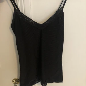Svart linne med spets - Jätte fint svart linne med spets och svagt randigt mönster. Från Vero Moda i storlek S💖