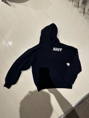 Vintage Hoodie - Nvy blå hoodie med boxy fit. Storlek S. Navy tryck bak och fram reflektivt