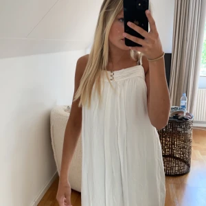Klänning  - Säljer denna jättefina vita klänningen från vila med spets längst ner, den är i bra skick. Skriv privat för flera bilder