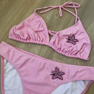 Ljusrosa bikini M - En tvådelad bikini med paljetter och blomster.  Storlek 40/42 i både över- och underdelen 