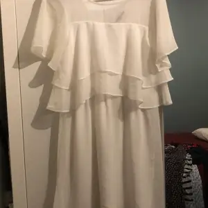 Säljer en vit klänning som är medellång, ungefär till knäna för en som är 158 cm lång. Klänningen är luftig och skön att ha på sig , v- ringad baktill och en liten del på framsidan och baksidan är genomskinlig. Använd enbart 1 gång. 