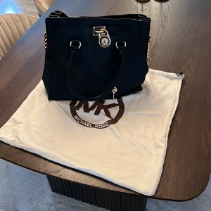 Michael Kors Väska  - Michael Kors väska använd endast 3 gånger, äkta!  Påse tillkommer och alla delar på väskan samt nyckel till låset.  Skick 9,5/10  Bred=36cm  Höjd=32cm  Perfekt till Jobb, daglig användning!  Pris kan diskuteras 