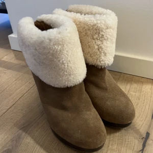 Ugg klackskor - Klackskor från UGG i brun mocka med "fluff" på utsidan, dock inget på insidan så de är inte överdrivet varma. Storlek 39. Endast använda en gång då de är för stora för mig. Kan gå ner i pris vid snabb affär! 