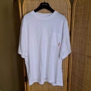 Acne Studios tshirt in white, with pocket and pink Acne label. New condition but bought at sample sale, red mark in label made before purchase. Oversized fit. Selling because of moving and having too many unworn tshirts. Amazing quality 