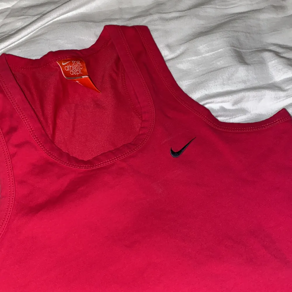 Cerise/rödfärgat sportlinne från Nike. Storlek M. Toppar.