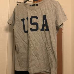 En grå t-shirt med trycket USA på