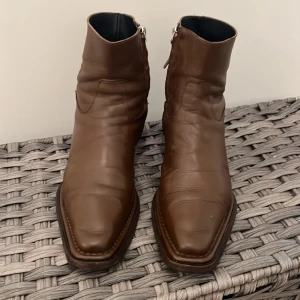 Acne Studios Man Boot - Jag säljer en Acne Studios herrstövel Brun storlek 45, användbar väldigt lite men som ny. ARTIKELINFO Ankelhöga svarta läderstövlar med paneler.  · Fyrkantig tå · Dragkedja på insidan · Kornigt läderfoder i svart · Staplad läderhäl med gummiinsprutning ·