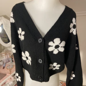 Blommig Svartvit Kofta - Svart kofta med vita blommor på, köpt på H&M för länge sen så finns inte kvar, super gullig & mysig så fundersam på om jag vill sälja denna men behöver pengarna så säljer vid bra bud💗funkar till både xxs som oversized men även xs & s