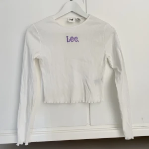 Topp från Lee💜 - Superfin oanvänd tröja från Lee!💜✨ Vit med lila text och lite vågigt i slutet på ärmarna och midjan. Tveka inte att kontakta vid frågor💫