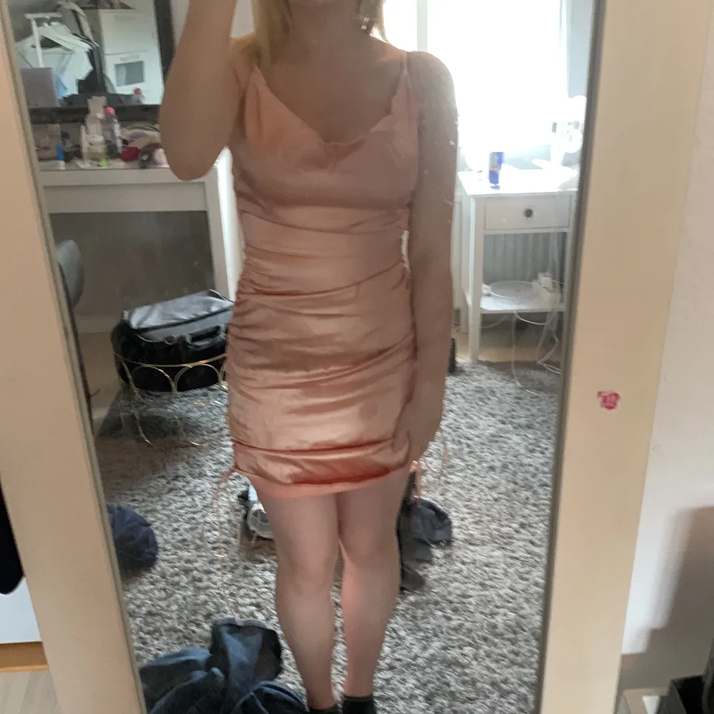 En ungefär rosa klänning som inte kommer till användning. Det står inte vart den är ifrån och den har en fläck under bröstet som inte syns när man har på sig klänningen. . Klänningar.