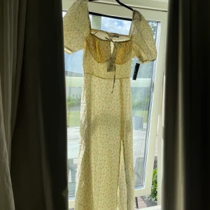 Sommarklänning med slits - Helt ny och oanvänd sommarklänning från NAKD. En jättefin klänning, tyvärr för liten för mig, med slits och fina detaljer. Klänningen har prislappen kvar och skulle säga att den passar en S och en M om du vill att den sitter lite tajtare. 