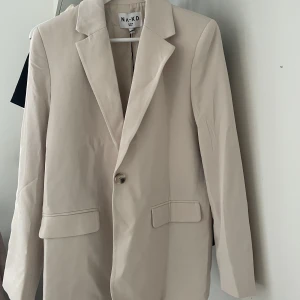 Begie basic kavaj  - Nakd. Helt oanvänd då den är för lång på mig som är 150cm. Storlek 32 men fortfarande lite oversize på mig som normalt har xs-s. 