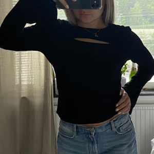 Svart långärmad topp med cutout - Så snygg tröja från NA-KD med cutout fram och vidare ärmar! Perfekt till allt!