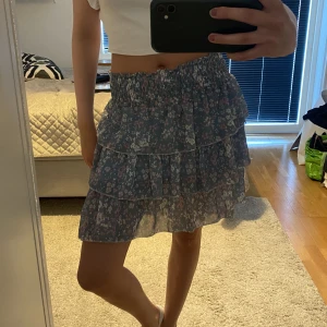 Volangkjol - Blommig volangkjol. Köparen står för frakten. Väldigt stretchig. 