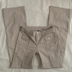 Lågmidjade jeans  - Populära lågmidjade jeans från H&M i en grå/beige färg. Aldrig använda!! Slutsålda på hemsidan🙌🏼Midjemått rakt över 34 cm och innebenslängd 81 cm. 