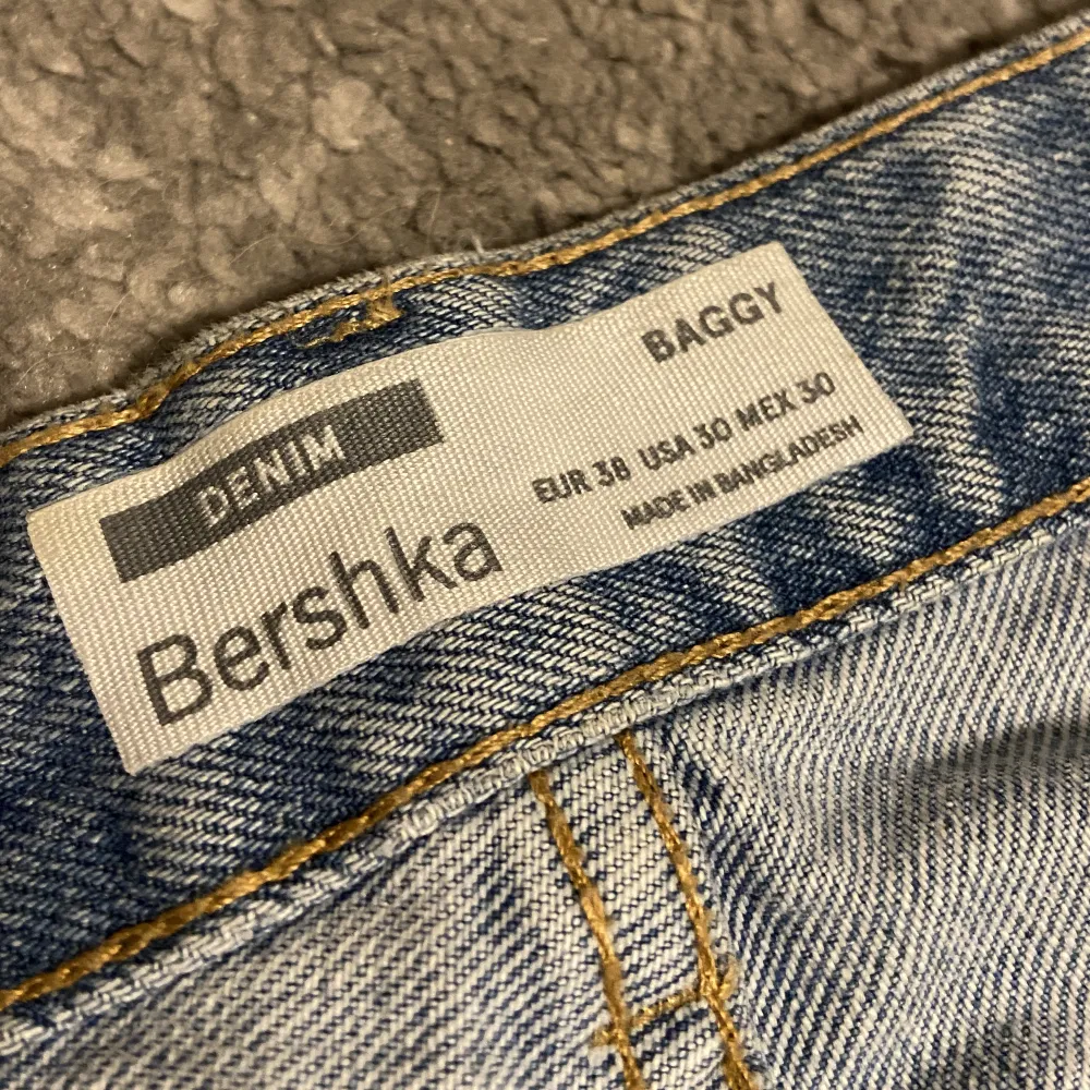 blåa baggy jeans från bershka i storlek 38. använda fåtal gånger. modellen är lite mer som straight leg jeans än baggy.. trasig längst ner på båda byxbenen (pga har blivit trampade på).. Jeans & Byxor.