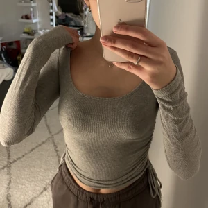 Grå långärmad tröja  - Säljer min gråa långärmade tröja som aldrig kom till användning💕 Den har justerband på båda sidor💕