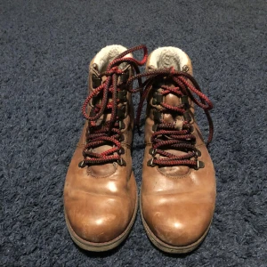 Kängor  - Bruna läder kängor, synligt använda men hela och fina fortfarande. Flanel tyg på insidan med fluff vid ankeln, tjocka starka skosnören:)
