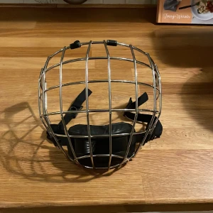 Ccm kromat galler - Ett CCM galler i mycket bra skick. Det är kromat och jag har tejpat över CCM märket på hakskyddet. Storleken på gallret är small