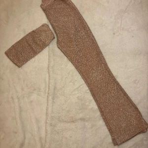 MATCHANDE SET  - Ett komplett sett med tubtopp samt byxor i guldglittrande material. Använt endast vid ett tillfälle. Passar XS-S.