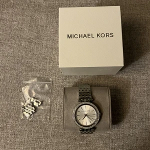 Michael kors klocka - en klocka från michael kors med medföljande förpackning, sparsamt använd och väldigt stilren och snygg. Har kortat av den så länkarna som är avtagna följer också med 