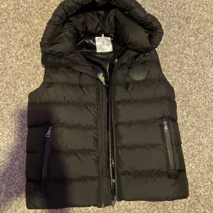 Monclerväst strl M - Pris går att diskuteras!! Väldigt fin och inte mycket använd. Säljs då den är för stor för mig och inte kommer till användning, fick i present därav inget kvitto osv.  Den passar till både killar och tjejer. Skicka privat för mer info 👌🏼