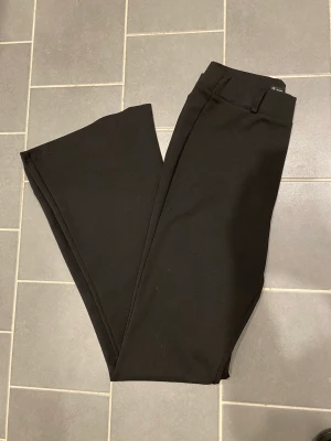 Kostymbyxor med utsvängda ben - Sjukt snygga kostymbyxor med utsvängda ben i storlek M. Stretchigt material!  Förlånga för mig som är 160!