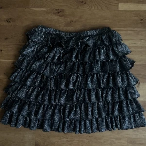 Svart volangkjol med silverglitter - Svart volangkjol med silverglitter från Zara i strl 152 men skulle säga att den passar XS/S 💓funkar att använda som både topp och kjol 💕gratis frakt!! 