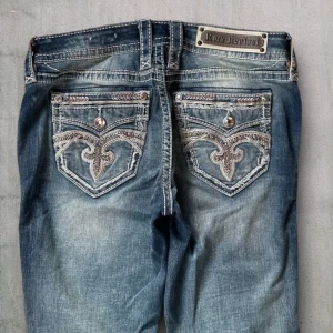 R10 Rock Revival Bootcut jeans  - Rock Revival jeans i model Easy Boot 💜 Tag 27W 💜Midja (rakt över) 40cm 💜 Innerben 82cm 💜 Ytterben 102cm 💜 Benöppning 23cm 💜 Småfläckar 💜Våra mått blir W=31, L=32 💜 Men jämför alltid måtten💜R10