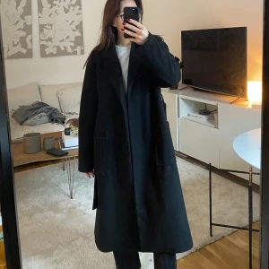 Svart oversize kappa - Intressekoll på min svarta kappa. Används inte så mycket då den är för stor i storleken för mig. Stora fickor i fram & band i midjan som går att knyta