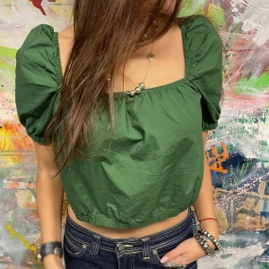 GRÖN PUFFTOP - Grön croppad topp med puffärmar, (kan göras off shoulder). Storlek S men kan också passa M. Modellen är 175 cm. Hör av er vid frågor/fler bilder. 