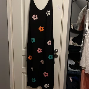 Svart klänning med blommor - Fin svart klänning med blommor i olika färger, aldrig använd. Köpte för 150kr - säljer för 50kr💘 Frakt ingår ej, men kan mötas upp om du bor i Örebro!