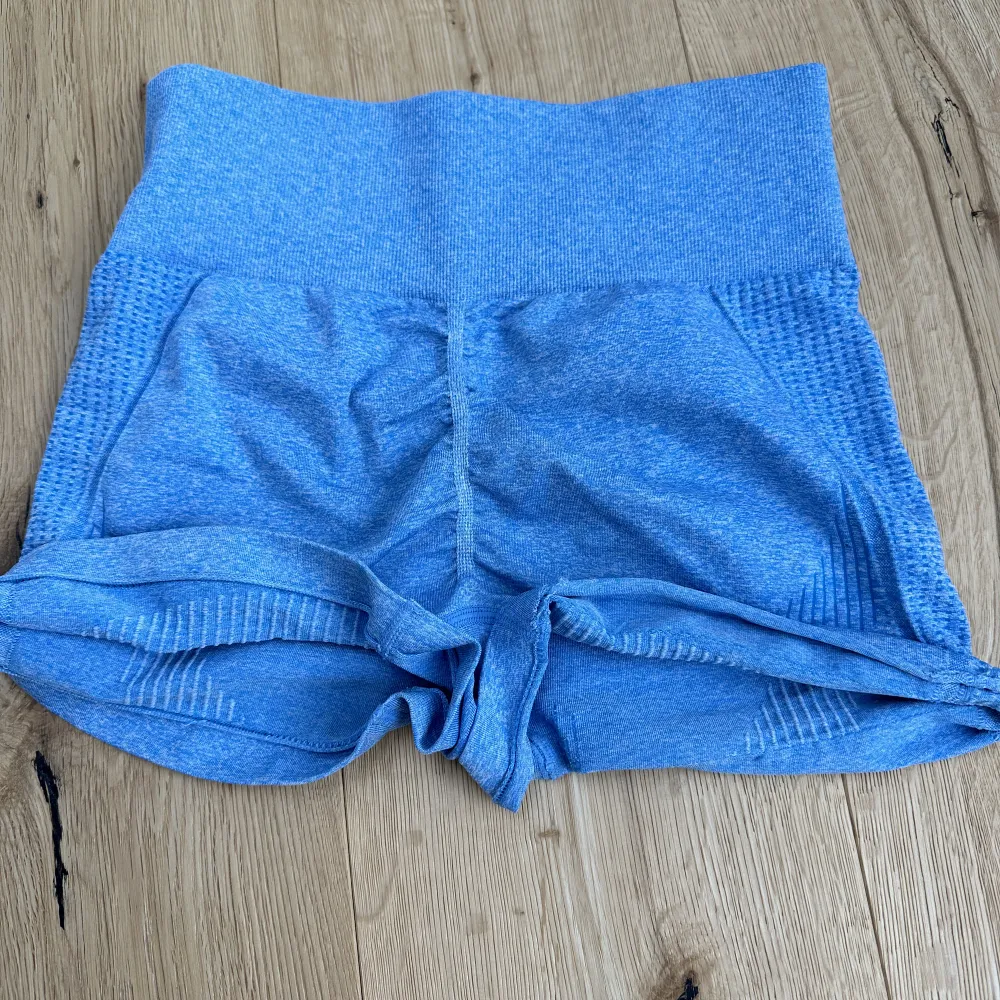 Säljer mina blå gym shorts i storlek S💙En tråd som har kommit upp och tyget runt högerbenet har vikt ner sig lite, se sista bilden!💙. Shorts.