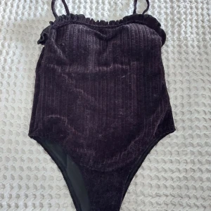 Velourbaddräkt - Kan använfas som baddräkt eller body/linne. Justerbara axelband och tunn vaddering isydd i bysten. Stretchigt velourtyg. Mycket högt skuren gren. Slimming.