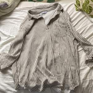 Randig skjorta med tre- kvartsäemar och slits på sidorna 