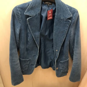 Blå Manchesterkavaj  - Supersnygg turkosblå manchesterkavaj. Fickor framtill med sömmar. Figursydd storlek S-M