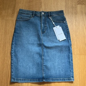 Ny jeanskjol från Vila  - Ny jeanskjol med lapparna kvar. Stretchig och mjuk i materialet och högmidjad med en liten slits bak. Köpte för 350kr och säljer den för 250kr. 💙