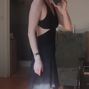 Svart miniklänning med utskurna detaljer - Miniklönning. Aldrig använd - enbart provad. Lappar kvar. Utskurna detaljer och korsade band i ryggen  Klantat mig rejält och råkat beställa flera stycken (..?!) I både 32 och 34. Så uppmärksamma strl ifall du klickar "köp nu" :)  jag klarar mig med en😅