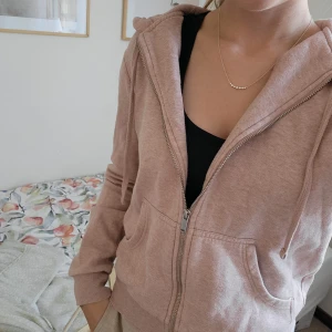 Zip-up hoodie - Rosa zip-up hoodie. Lite "luddig" och har ett litet hål (se bild 3). Har klippt bort lappen där det ska stå storlek men tycker denna passar xs-s.