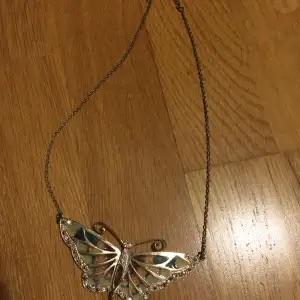 super fint fjäril halsband med guld kedja. fjärilen är ganska stor och har jätte fina färger och strass på vingarna. halsbandet köptes av min mamma på accessorize i Libanon för många år sedan och säljs inte längre. 