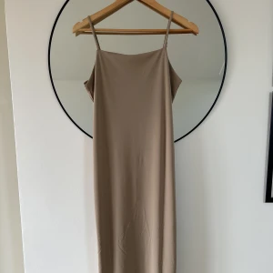 Klänning  - Beige klänning i polyester från h&m. Aldrig använd och slutar lite nedanför knäna. 
