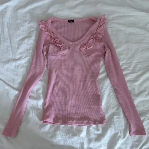 rosa tröja  - rosa tröja med volang köpt secondhand. OBS skulle säga att den bara passar någon med små bröst då den t.ex hela tiden glider över brösten på mig/passar inte alls 