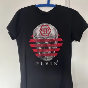 Philipp Plein Crystal Embroided T-shirt (Junior 14Y) ÄKTA (DUBAI) - T-shirten har endast används ett par gånger då den var liten för mig som ör strax 16. Den är i perfekt skick/form och har inga problem alls.  T-shirten var beställt från Dubai och kostade ett par tusen kronor då den är äkta också. 