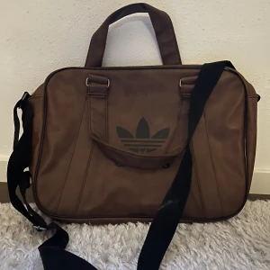 Adidas axelremsväska  - En jättefin axelremsväska från Adidas i väldigt bra skick. Liten fläck på axelbandet som visat i bild♥️