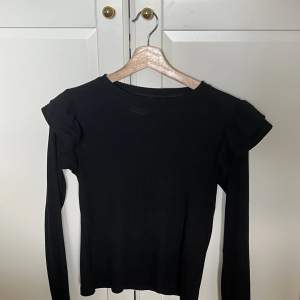En jättefin och gullig svart ribbad (Finstickad) tröja från zara med volang på axlarna 💕 sparsamt använd och är i storlek S, kontakta gärna mig för mer info🫶🏼