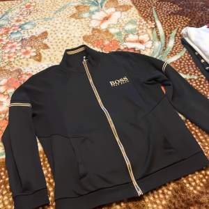 Hugo boss zip hoodie i svart guld färg, 9/10 skick nästan helt ny. Nypris på zalando 1400 