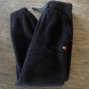 Mjukisbyxor! - Tommy Hilfiger mjukisbyxor, lurviga som syns på bilden. Dom är svarta och lika mjuka i insidan som utsidan! Endast använda en gång pågrund av fel storlek! 