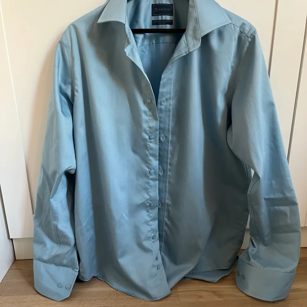 En himmelsblå skjorta i 100% bomull. I ett mycket bra skick! Storlek 41,42. Skjortor.