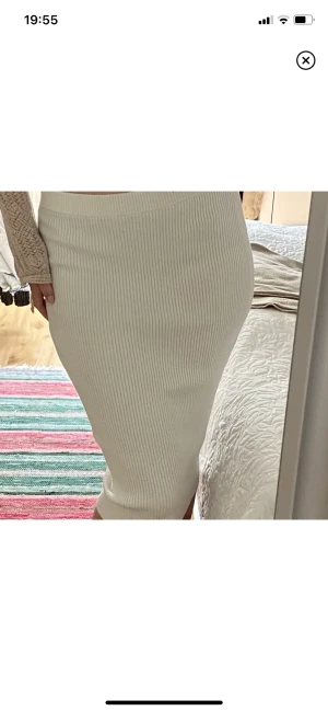 Stickad kjol - Säljer denna fina stickade/ribbade vita kjol från hm. Är 170 cm för referens. Passar också som klänning! Kan bäras både lågmidjat och mellanmidjat. 